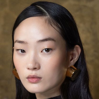 A close up of a model backstage at fashion week with glass skin - spicules skincare