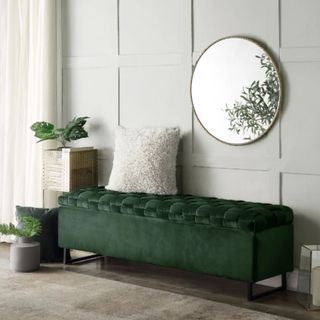 Inspired Home Lilliana Upholstered Velvet Storage Bench in dark green in living room by panelled wall with round mirror above, cushion on top and plants beside it
