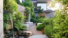 modern coastal garden with water feature, natural boulders, naturalistic planting and gravel path