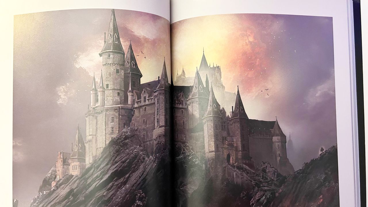 A photo of an Elden Ring concept art book. A tall manor's spires pierce the burning sky. The entire castle sits on top of a black mountain.