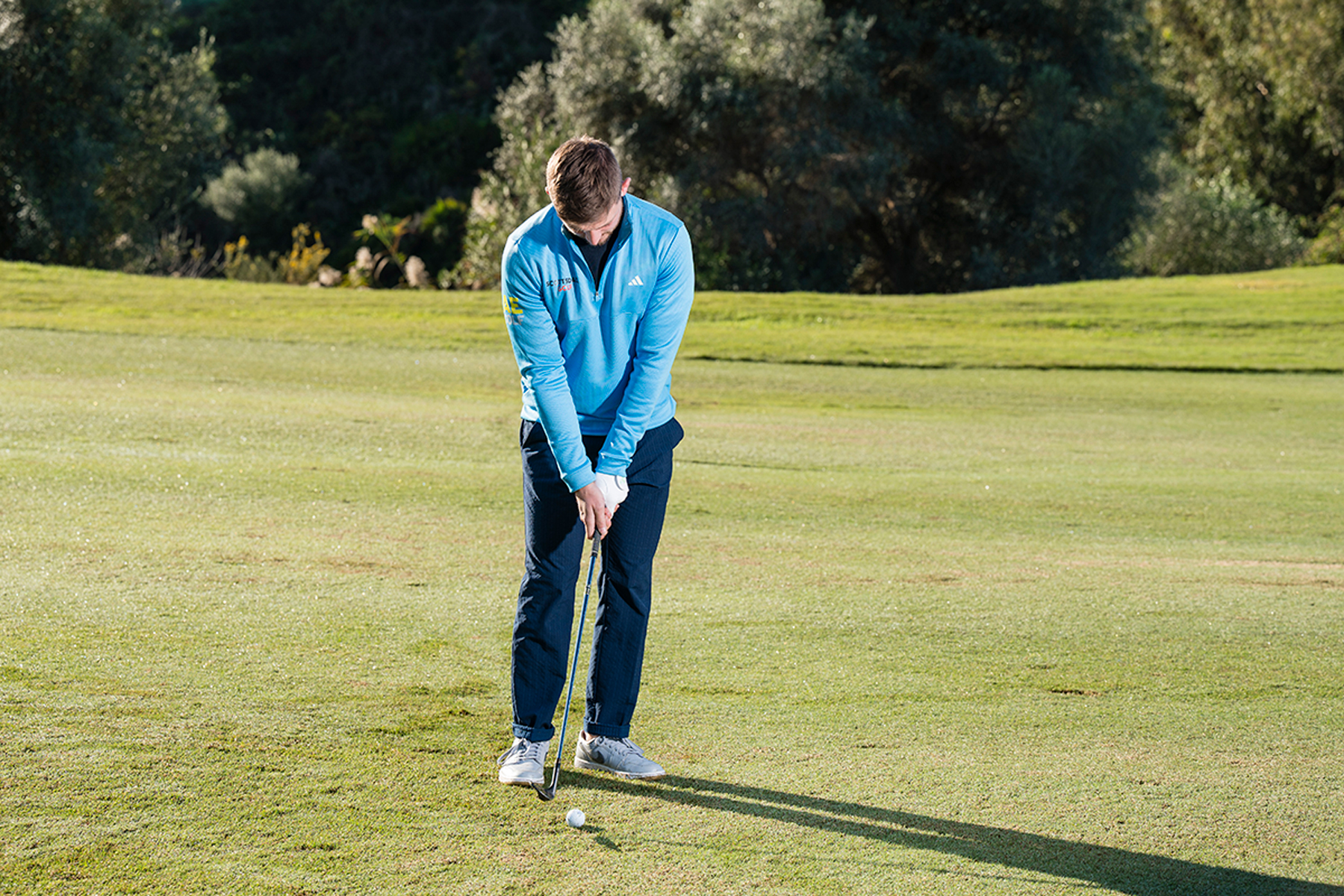 PGA Pro Alex Elliott demonstrating the correct setup for a pitch shot, with weight 60% on his lead side and hands slightly forward to create shaft lean