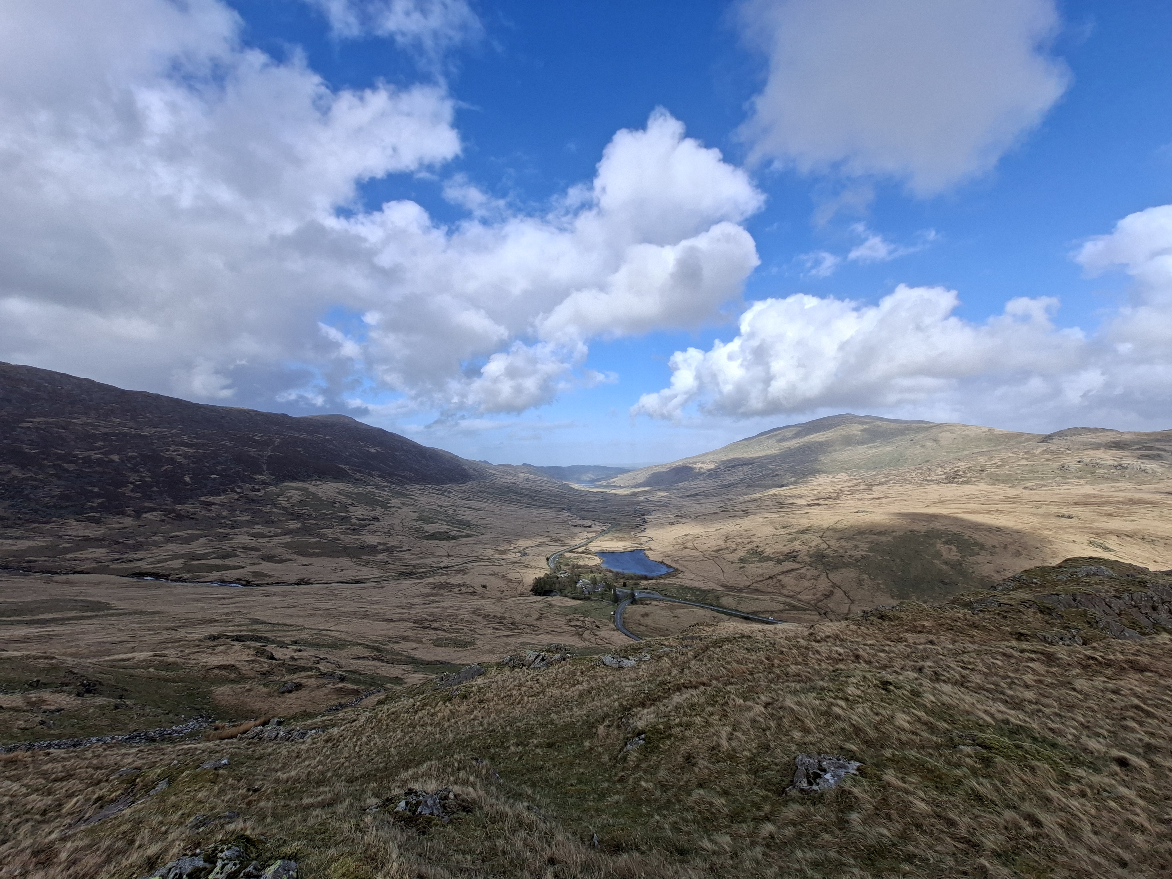 A photo taken on the Samsung Galaxy A57 showing an ultra-wide picture of some hills and a lake.