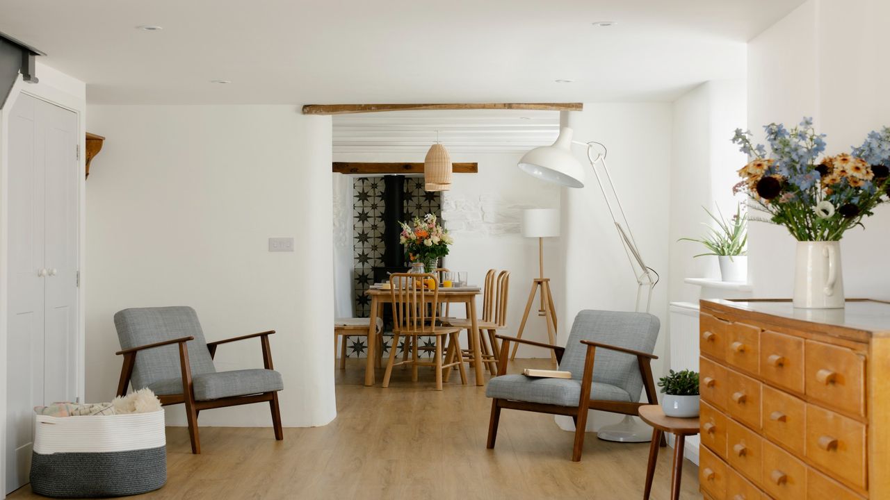 White room with two arm chairs and dining table