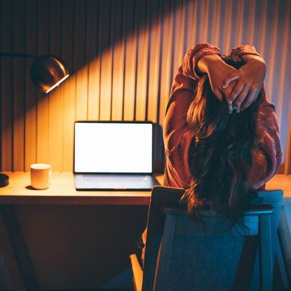 A frustrated worker sits at her desk.