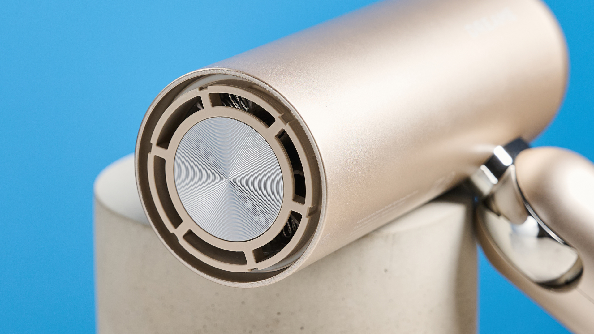 The Dreame Pocket Neo in gold photographed in front of a blue background.