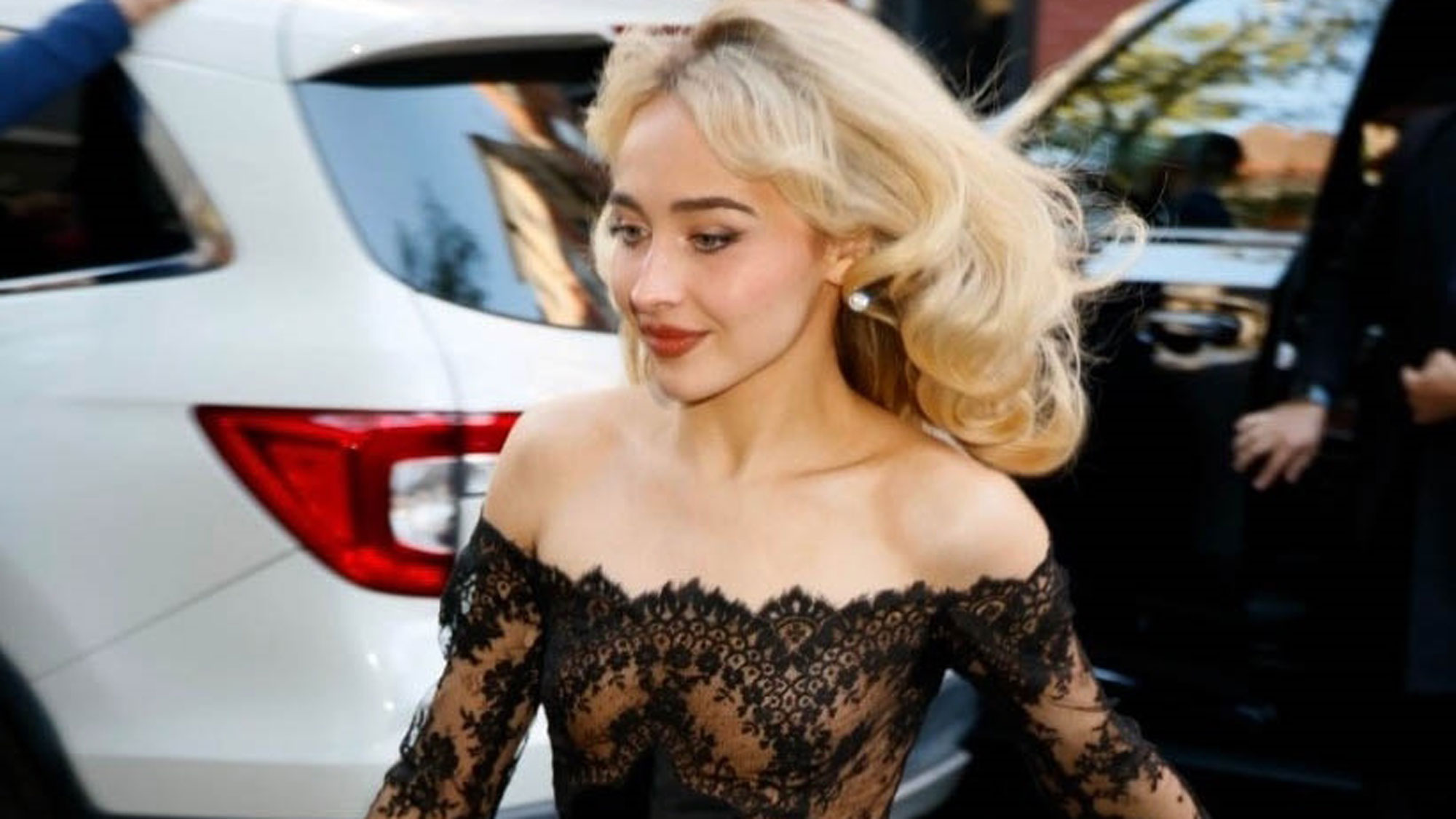 Sabrina Carpenter wears a black lace dress
