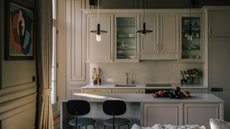 A traditional beige kitchen with modern twists on things like the bar stools