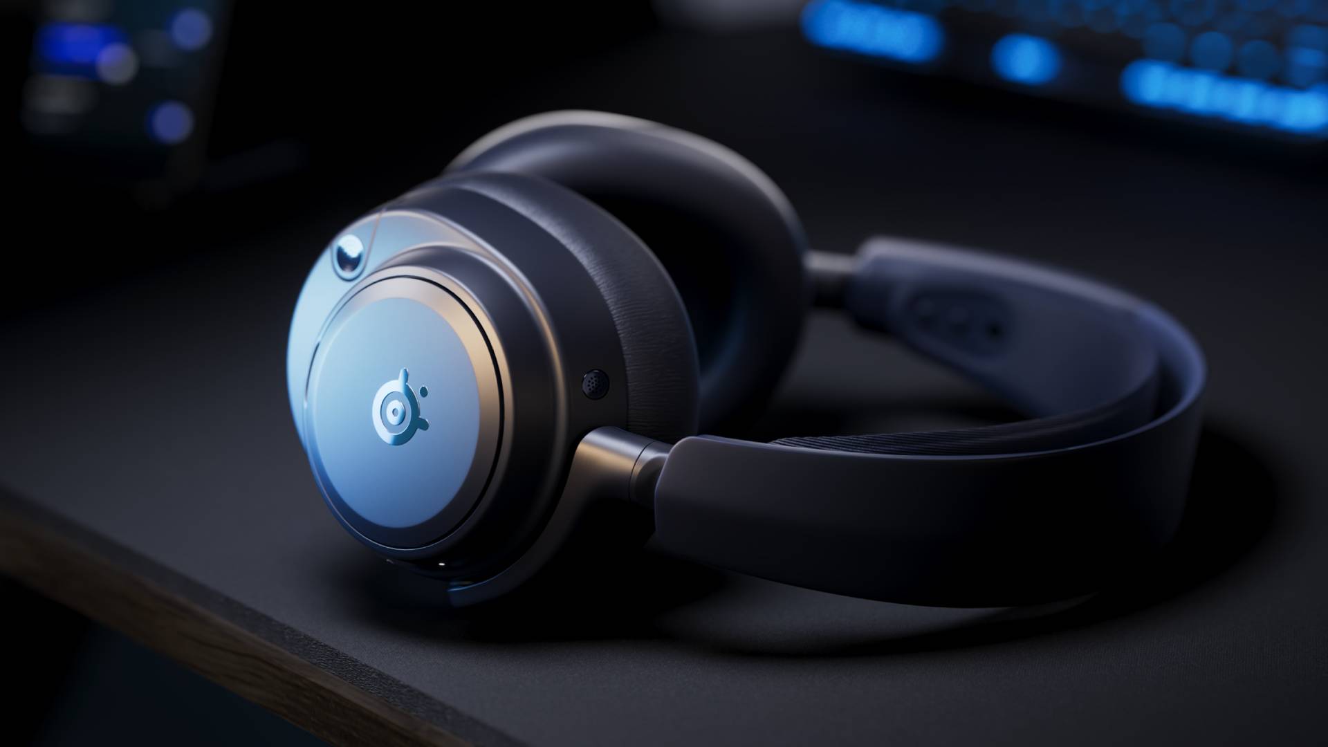Image of the Midnight Blue Arctis Nova Pro Omni headset sitting on a black desk.