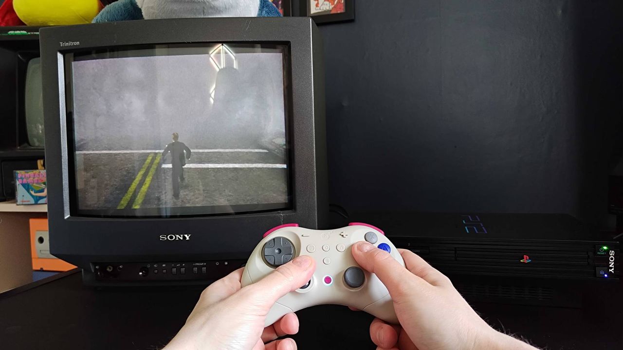 Hands using Gulikit Elves 2 Pro to play Silent Hill 2 on a PS2 connected to a Sony Trinitron CRT TV.