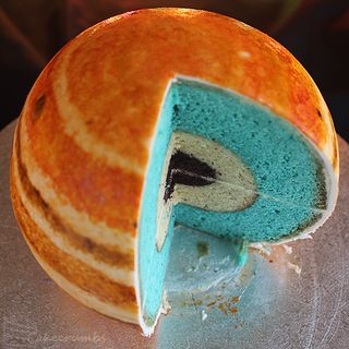 The planet's core is made from mud cake, almond butter represents a layer of liquid metallic hydrogen and the blue-colored vanilla Madeira sponge cake is representative of molecular hydrogen. Image uploaded on Aug. 27, 2013.