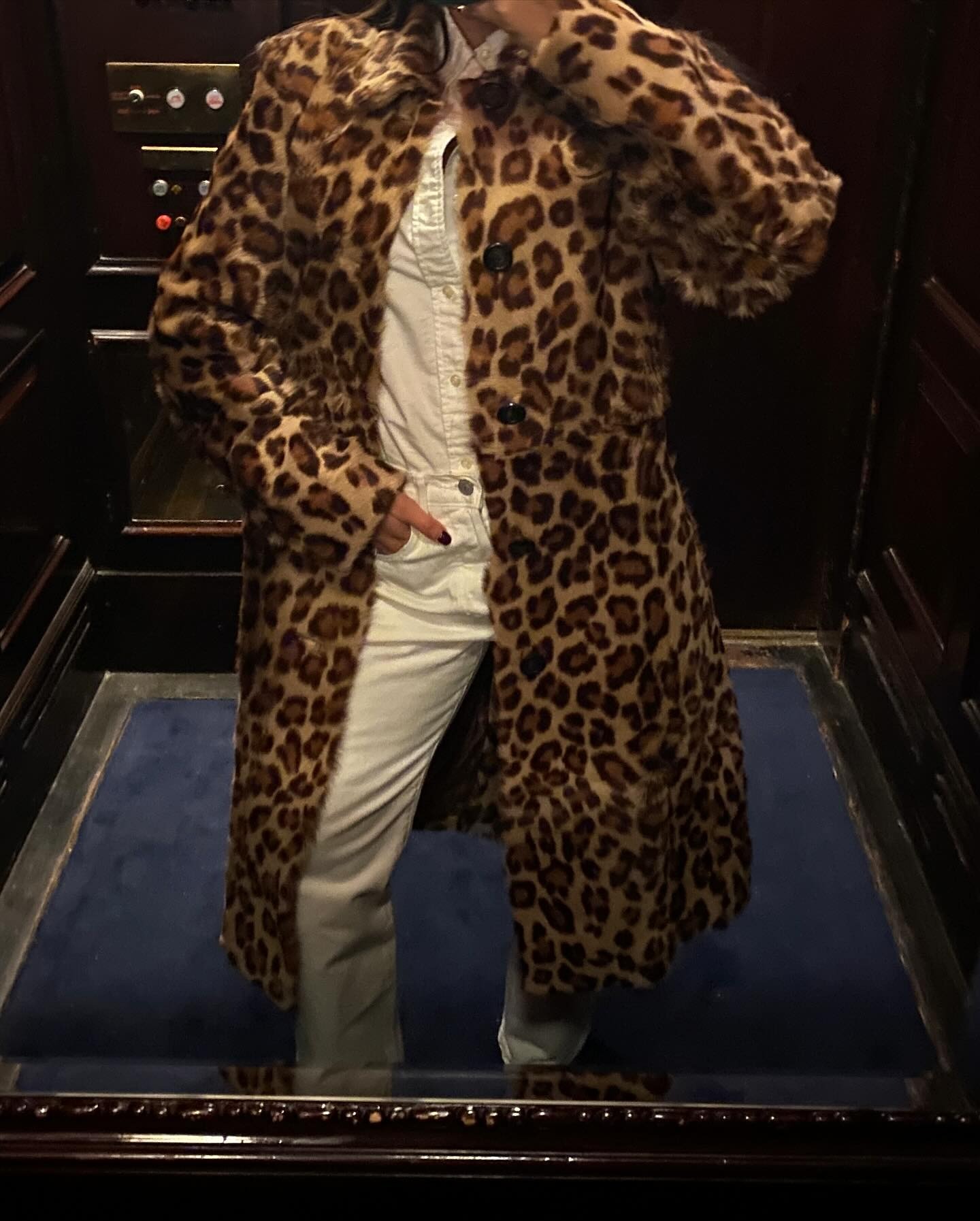 @themillennialdecorator wearing a leopard-print Ralph Lauren coat with a white button-down shirt and white jeans.