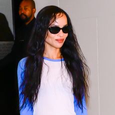 Zoe Kravitz wearing a baseball T-shirt, slip skirt, and ballet flats