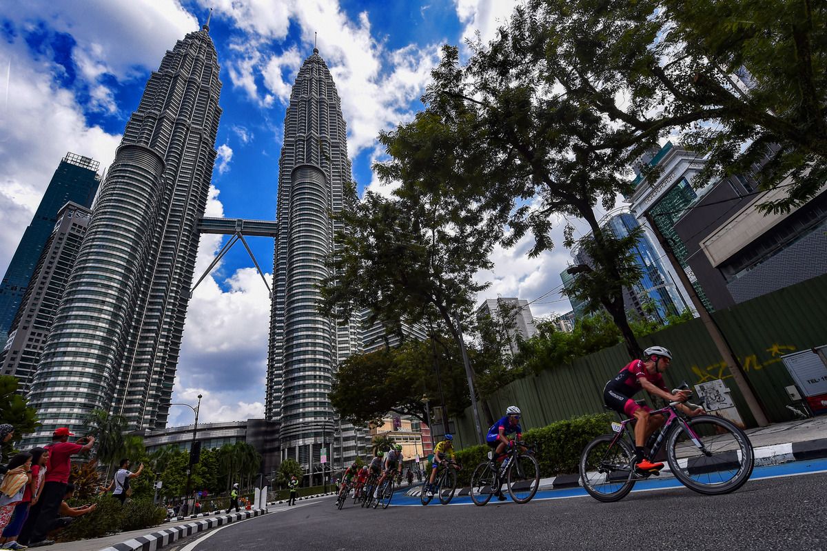 The peloton passes the Petronas Towers in KL