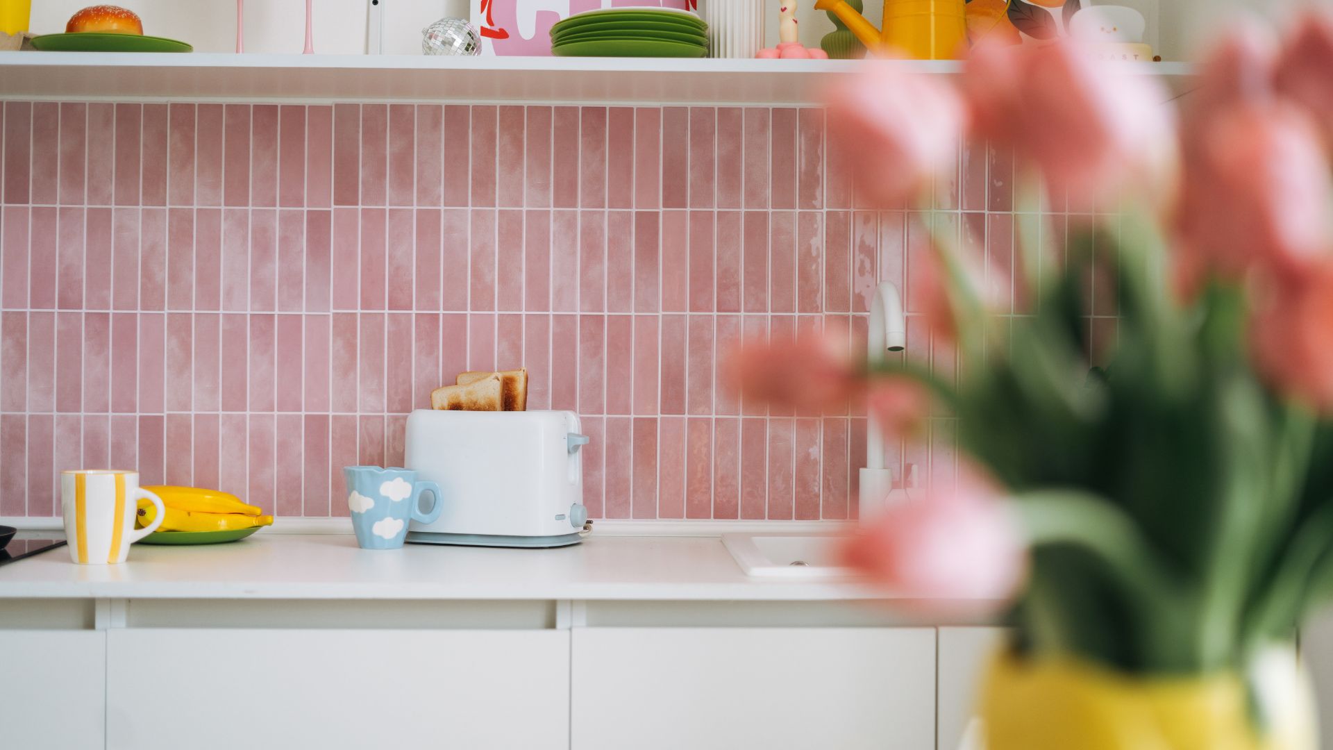 picture of white kitchen with pink subway tiles as a backsplash
