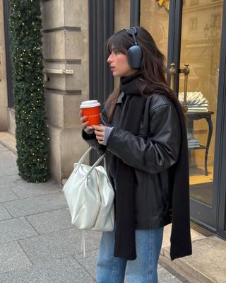 French influencer wearing a leather bomber jacket.