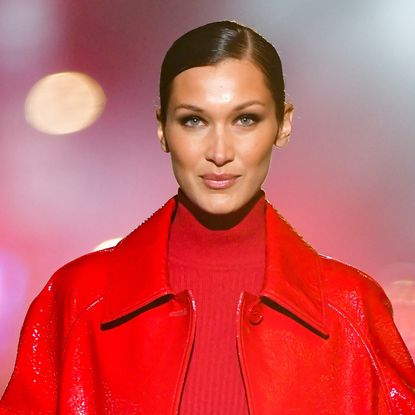 Bella Hadid wearing a red jacket and red top on the runway in 2021 for Michael Kors
