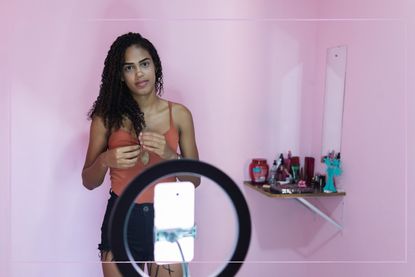 girl videoing herself for social media in bedroom