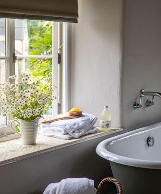 Bathroom with rolltop bath and tiled windowsill