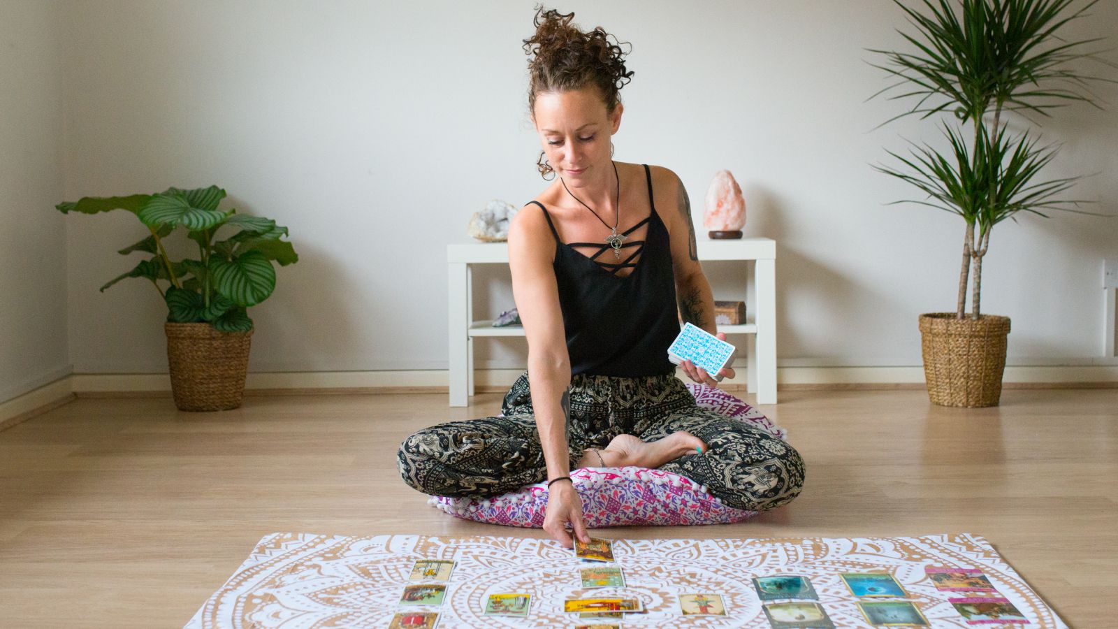 Mujer leyendo cartas del tarot en sala espiritual
