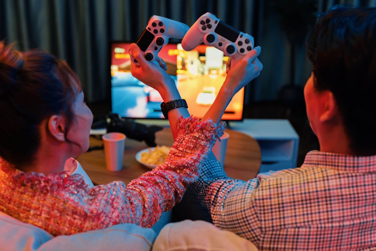 A couple playing video games crossing their controllers