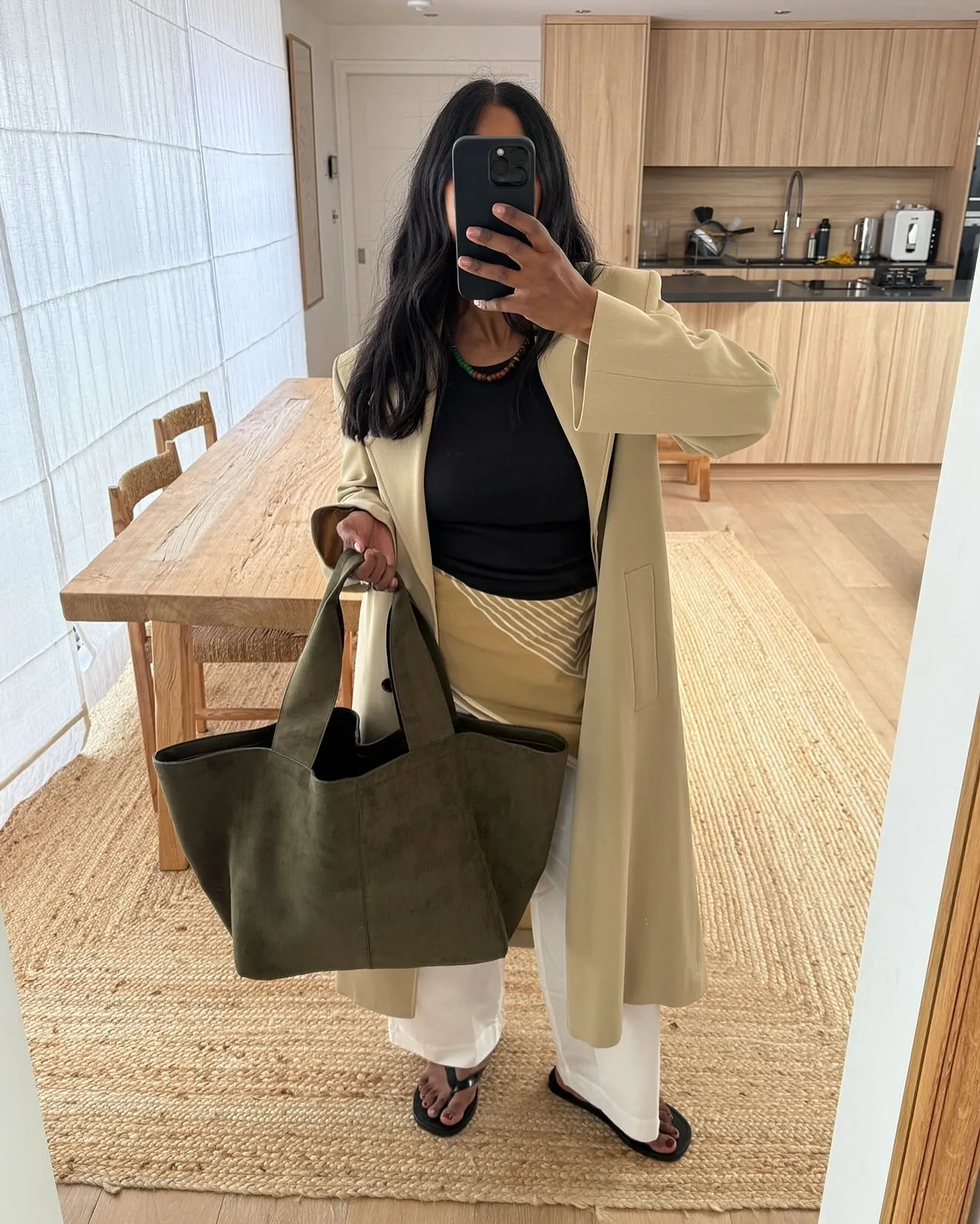 Woman carries burgundy suede Margaux bag by The Row