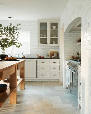 a classic kitchen with white tils over the walls