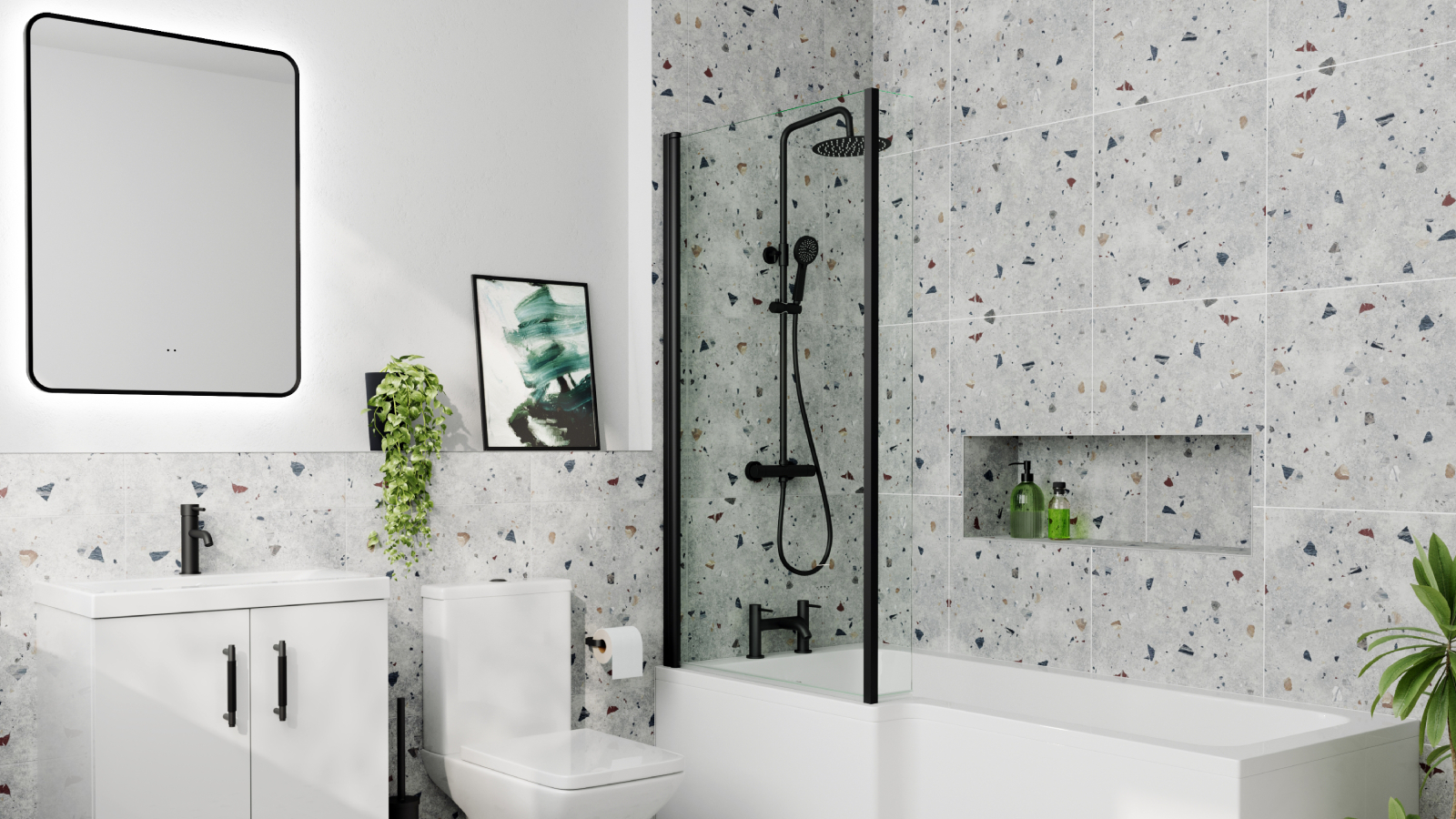 bathroom with l-shaped bath, black shower screen, toilet and white vanity unti with sink terrazzo style grey, white and black tiling on walls