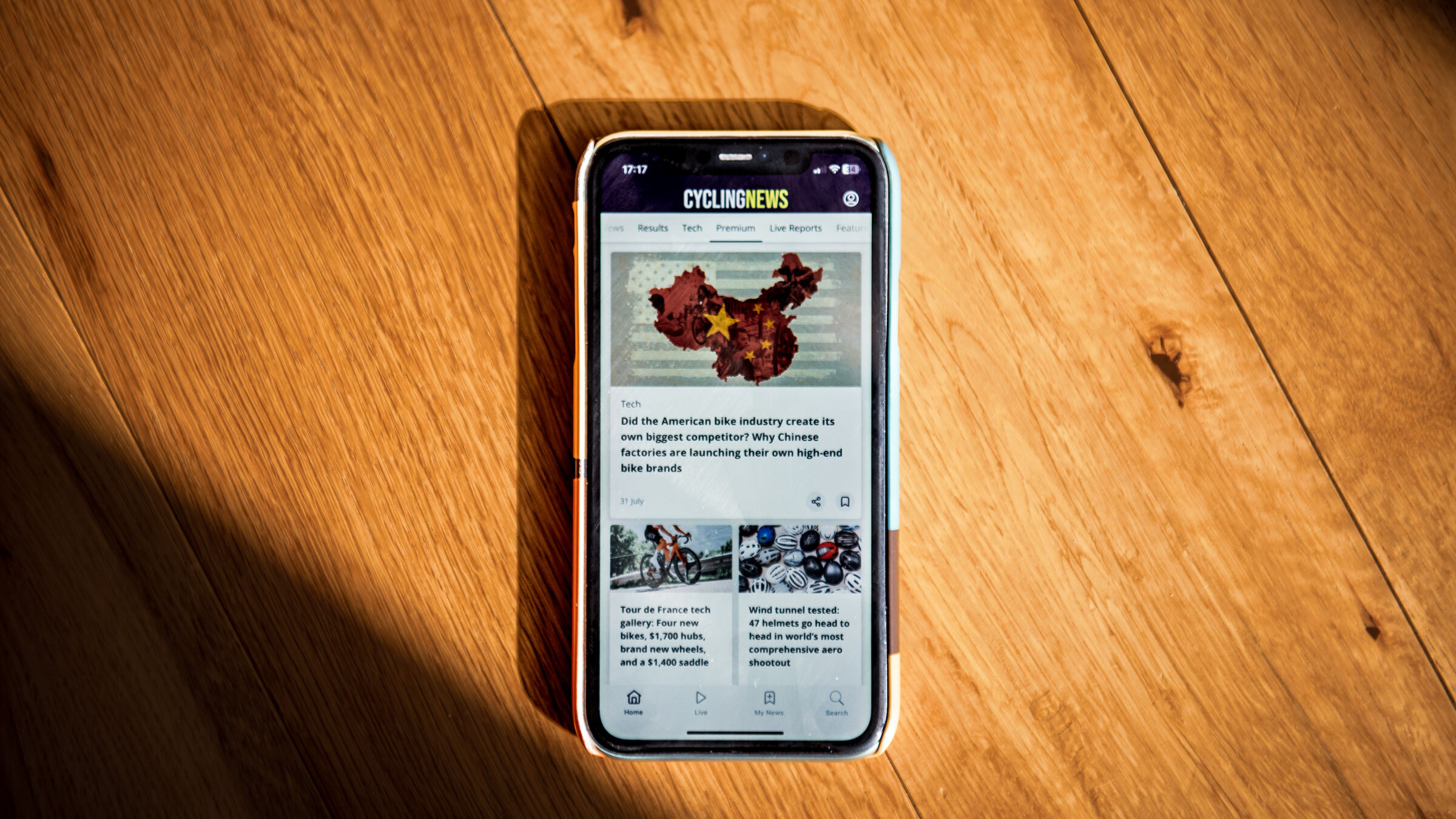 A phone on a wooden table displaying the Cyclingnews app