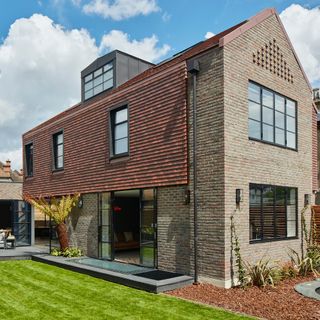 Double storey brick house with red tile roof