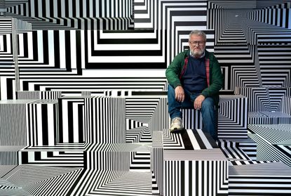Artist sitting in black and white stripy room