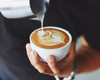 Pouring milk into coffee mug