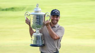 Xander Schauffele smiles as he poses with the 2024 PGA Championship trophy