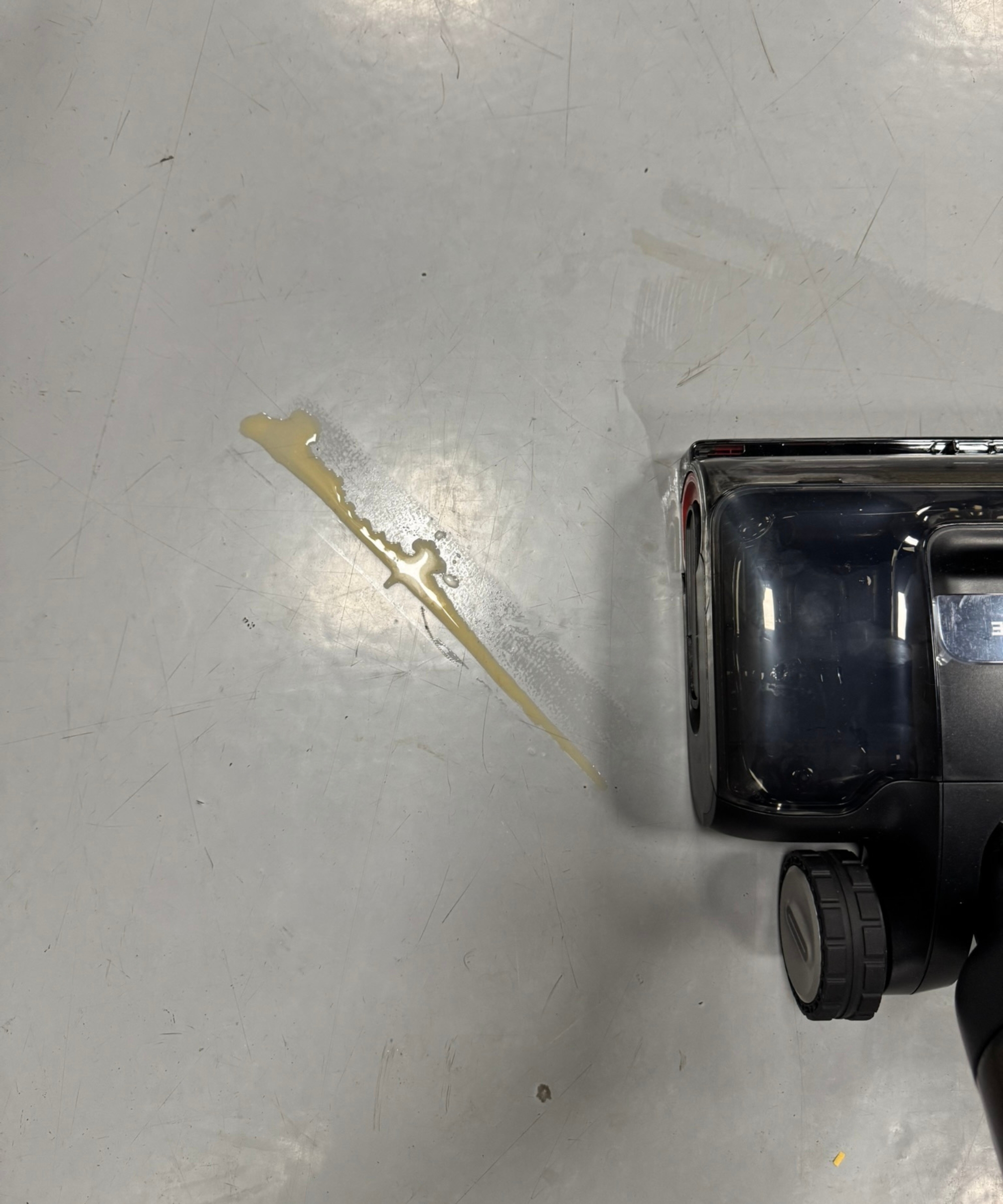 Brown liquid in a line on the floor, pictured next to Dreame H15 Pro CarpetFlex vacuum-mop floorhead.