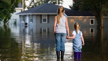 picture of two girls looking at a flooded house