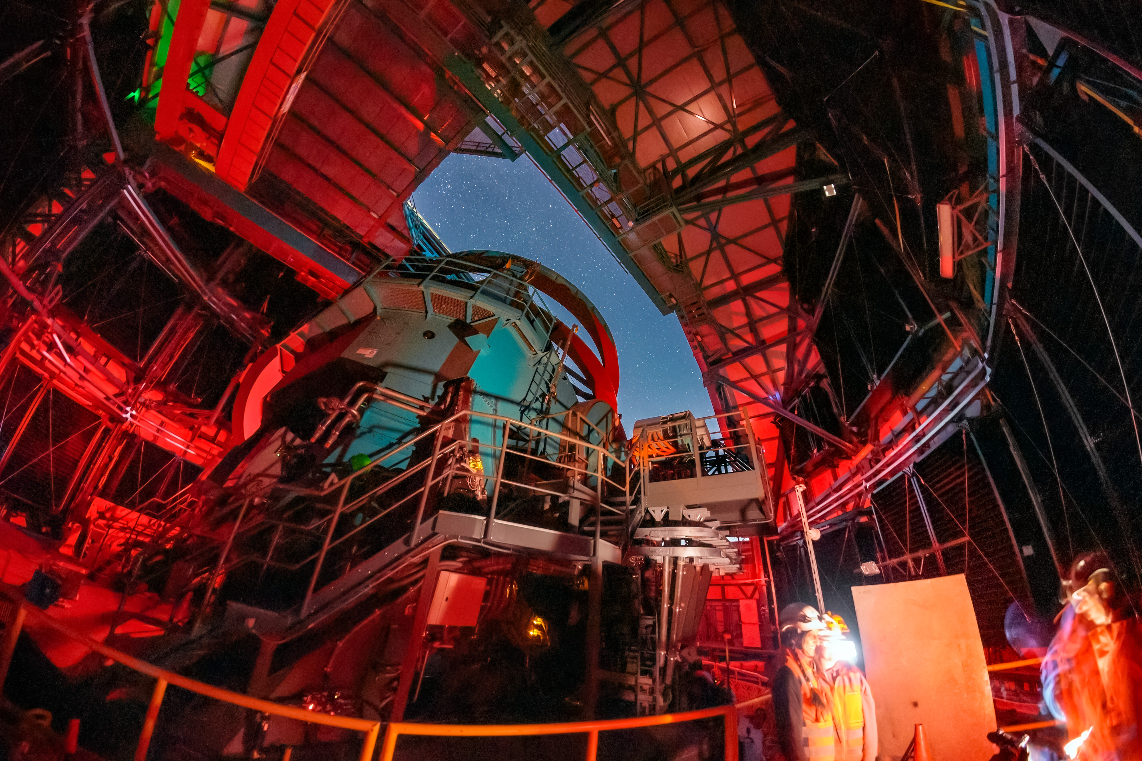 A telescope points upward at the night sky
