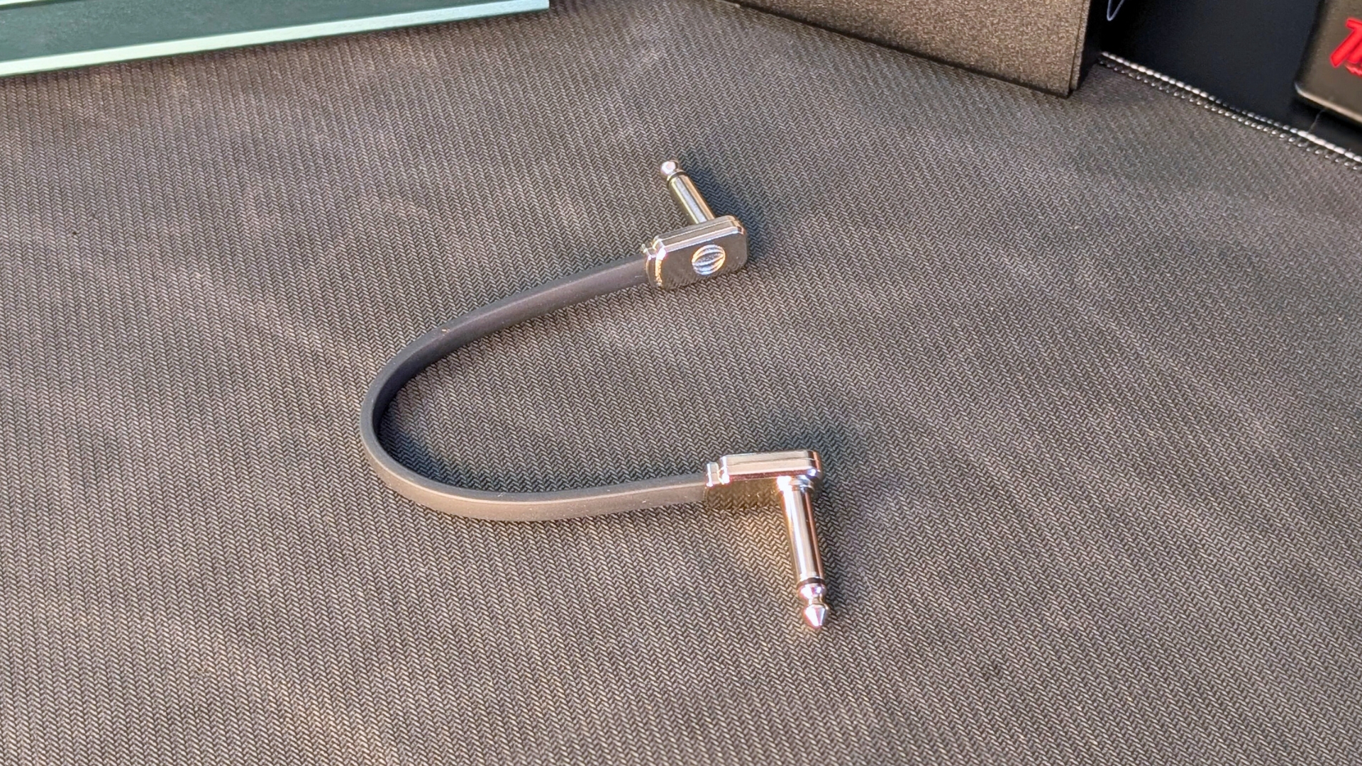 An Ernie Ball Flat Ribbon patch cable on a desk