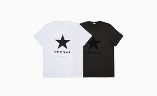 A white t-shirt laying over a dark grey t-shirt, both have a black star on them.