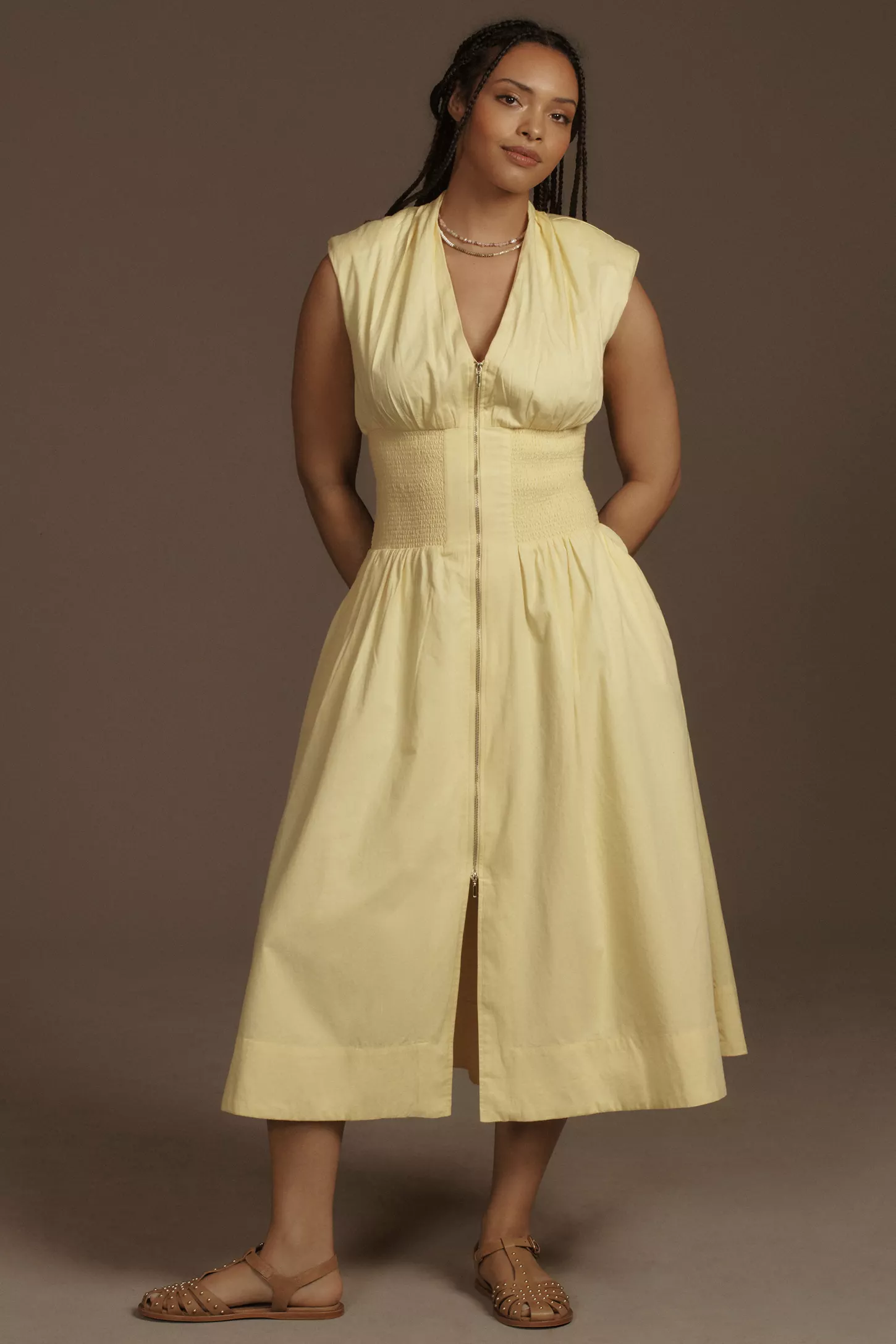 model wears yellow dress and brown flat sandals