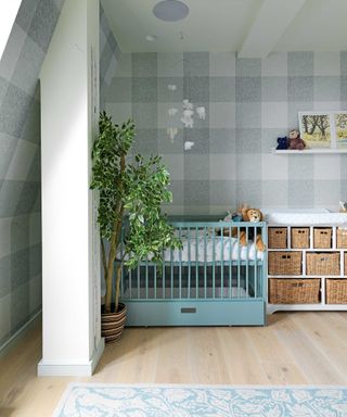 nursery with checked wallpaper, blue crib and cubby storage