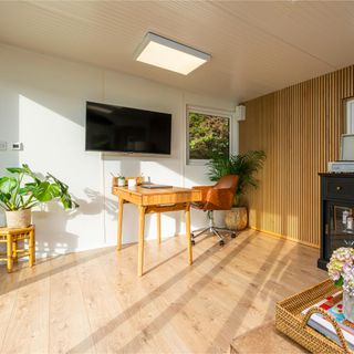 Interior of Green Retreats garden room with wooden floor, desk and houseplants