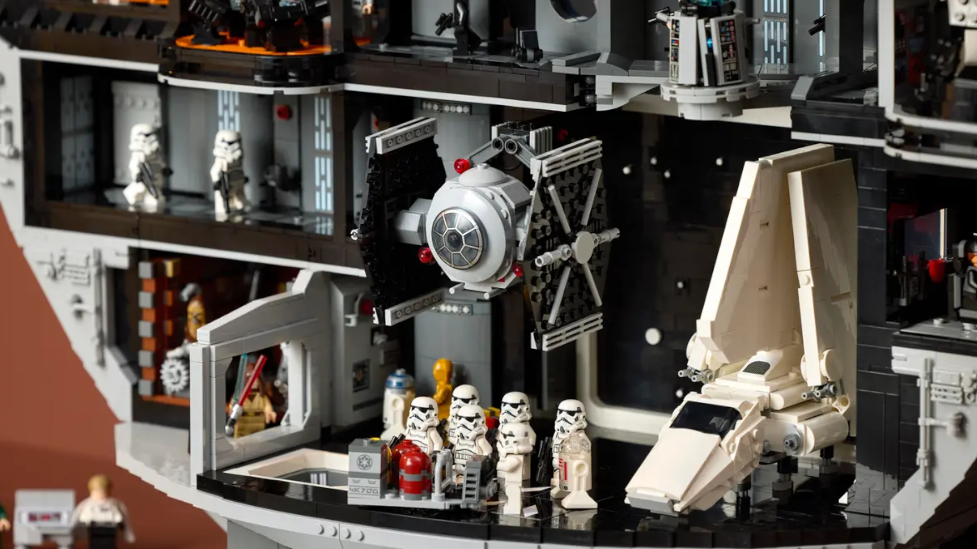 The Death Star hanger bay with a TIE Fighter and shuttle, surrounded by Stormtroopers and with other minifigures visible in the background
