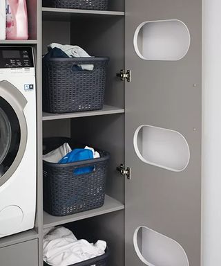 a grey built-in laundry sorting unit by Schüller, with a washing machine next to it