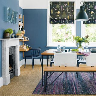 Blue dining room with floral blinds, sisal carpet and stone fireplace