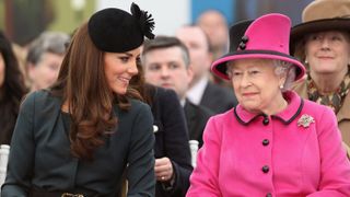Queen Elizabeth and Catherine, Princess of Wales watch a fashion show at De Montfort University on March 8, 2012