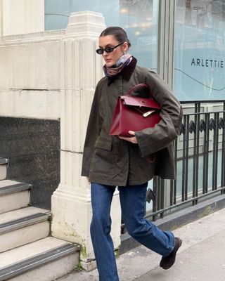 @sobalera wearing the Toteme Country Jacket with blue jeans, ankle boots, and a burgundy Hermes Kelly Bag in London