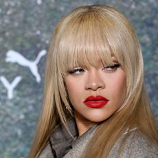 Rihanna attends a Fenty Puma event in London wearing a gray jacket and blonde hair