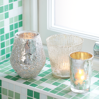 bathroom with green tiles and candle