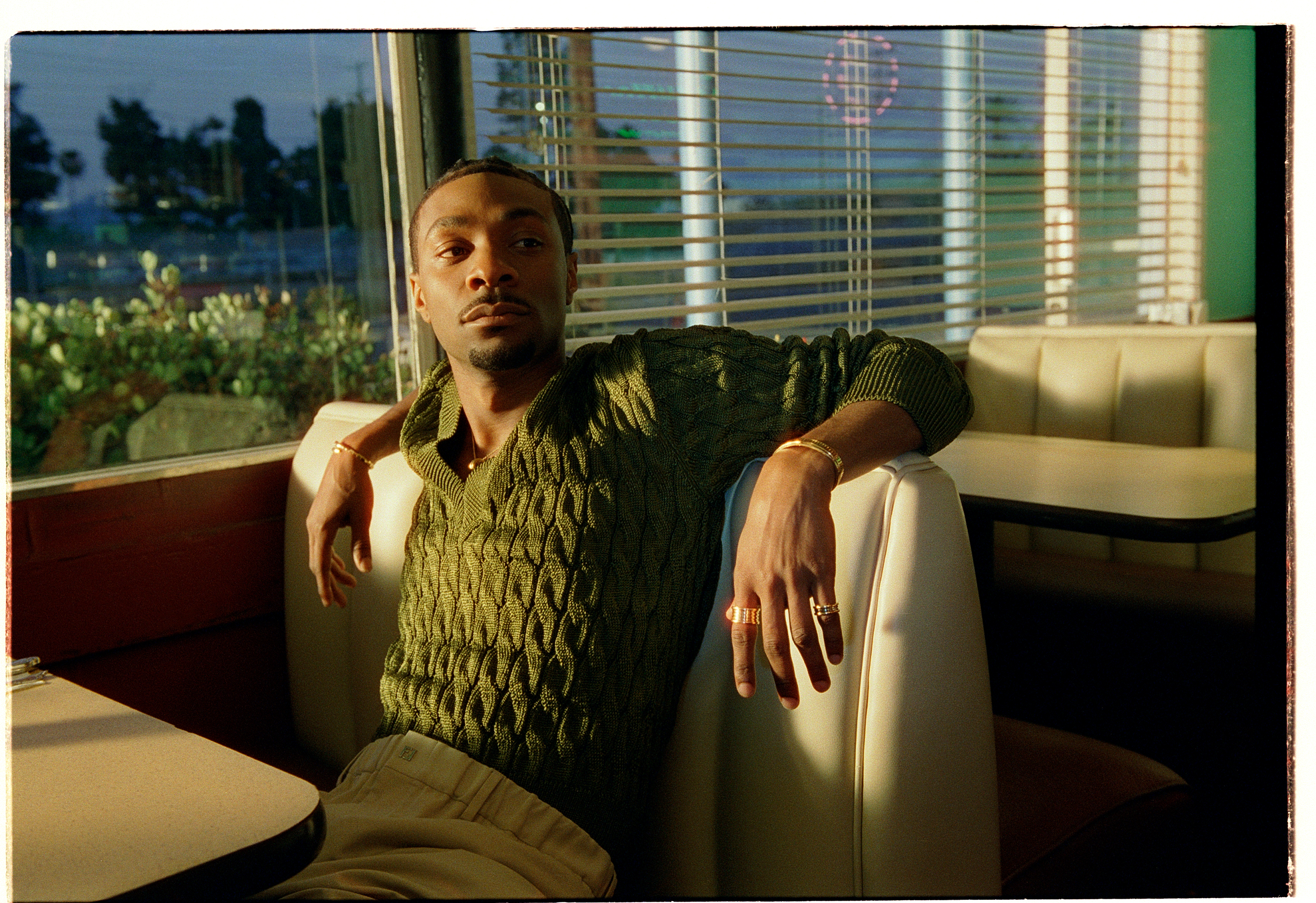 Jonathan Daviss in a green sweater and pants.