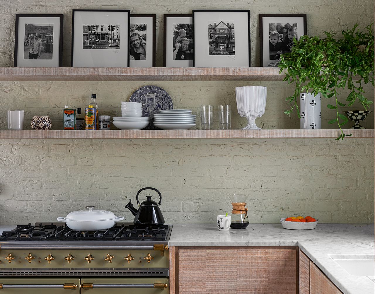 transitional style kitchen with green walls, wood cabinets and art on a shelf