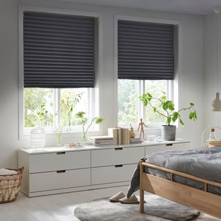 modern bedroom with double grey blinds and low storage